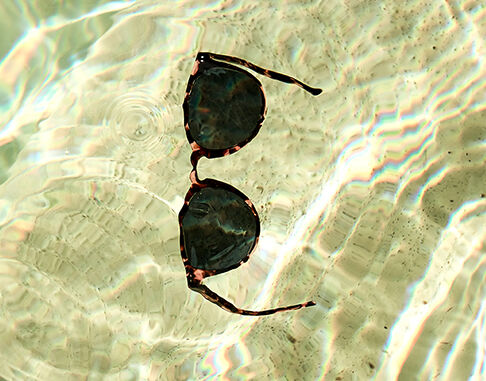Eine Hand hält eine zusammengelegte Brille